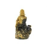 A Chinese carved soapstone figure of an immortal sitting on a gourd shaped rock, H. 11cm.
