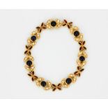 An 18ct yellow gold (stamped 750) bracelet set with cabochon cut sapphires, marquise cut rubies
