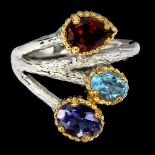 A 925 silver ring set with garnet, tanzanite and blue topaz.