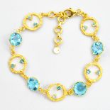 A 925 silver gilt bracelet set with faceted blue topaz, L. 21cm.