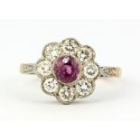 An 18ct yellow and white gold (stamped 18ct) cluster ring set with a pink sapphire and diamonds,