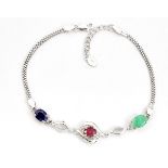 A 925 silver bracelet set with oval cut ruby, sapphire and emerald and white stones, L. 21cm.