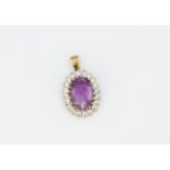 A 9ct yellow gold pendant set with a large oval cut amethyst and white stones, L. 2.5cm.
