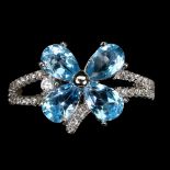 A 925 silver flower shaped ring set with pear cut blue topaz and white stones.