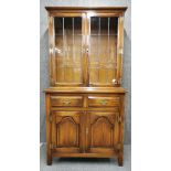 A carved oak bookcase over cabinet with leaded glass doors, H. 176cm.