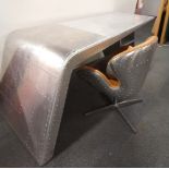 A contemporary aviator style aluminium covered desk together with an aviator style aluminium and