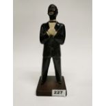 A 1920's carved and painted wooden figure of a Minstrel on a phenolic base, H. 25cm.