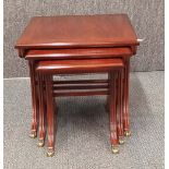 A wooden nest of three reproduction mahogany side tables, largest 50cm x 46cm x 53cm.