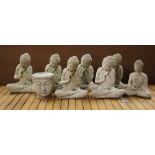 A group of eight concrete garden figures of the Buddha, H. 32cm.
