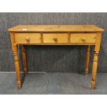 A three drawer pine side table, W. 107cm