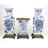 A garniture of three brass mounted porcelain vases, tallest 29cm.