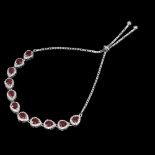 A 925 silver adjustable bracelet set with pear cut rubies and white stones.
