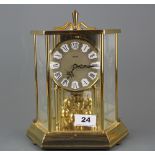 A Kundo gilt brass torsion pendulum clock with engraved glass panels, H. 25cm.