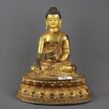 A Sino-Tibetan temple quality gilt and hand painted bronze figure of the Buddha seated on a double l