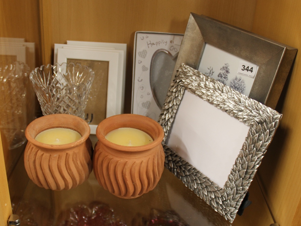 A pair of incense perfumed candles, a cut glass vase and a quantity of contemporary photo frames.