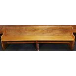 An antique church pew, L. 247cm.