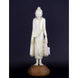 A 18th/ early 19th century Oriental carved ivory figure of the standing Buddha