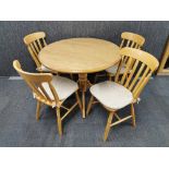 A circular pine kitchen table with laminate top with a set of four chairs, Dia. 100cm.