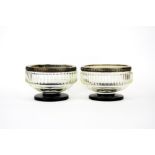 A pair of white metal rimmed continental cut clear glass bowls raised on black glass feet, Dia. 10.