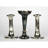 A pair of hallmarked silver candle sticks, H. 11cm. together with a hallmarked silver bud vase.