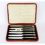 A cased set of 1923 hallmarked silver handled butter knives featuring the head of Tutankhamun issued