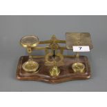 A Post Office scale and weights on a wooden base, W. 19cm, H. 8cm.