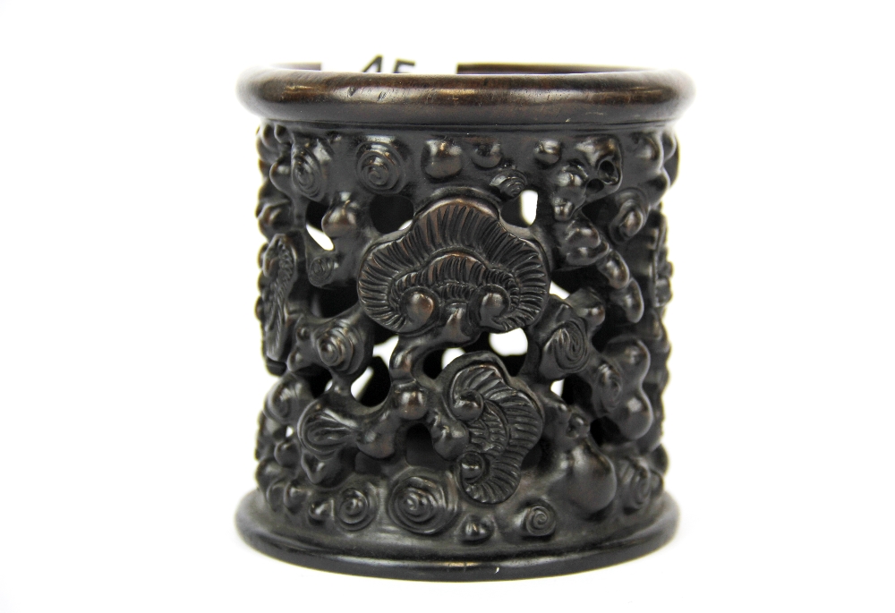 A Chinese carved and pierced dark wood brush pot decorated with ruyi shaped lotus leaves, H. 11cm,