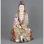 A Chinese hand enamelled porcelain figure of the goddess Guanyin holding a child, H. 29cm. Impressed