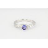 A 9ct white gold set with an oval cut tanzanite and brilliant cut diamond set shoulders, (N).