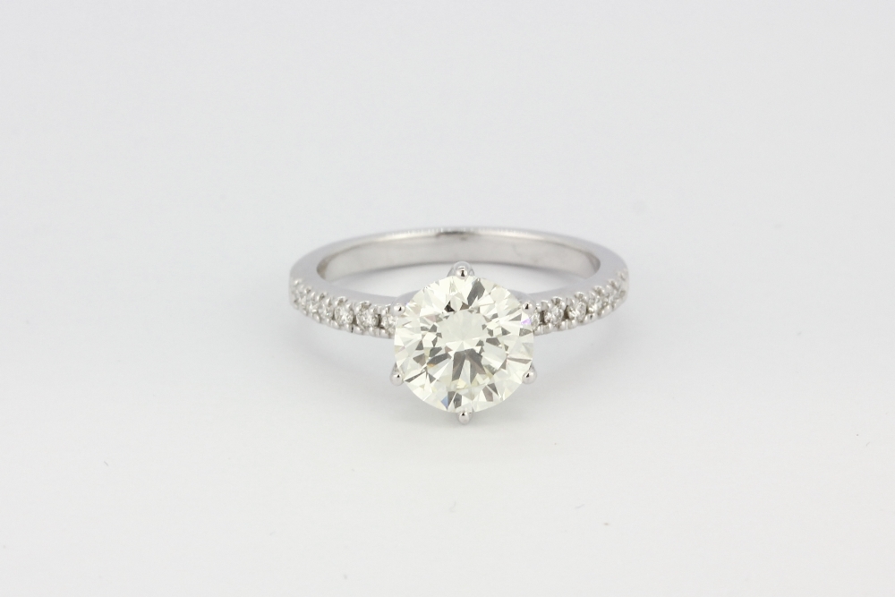 An 18ct white gold (stamped 750) solitaire ring set with a brilliant cut diamond and diamond set