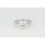 An 18ct white gold (stamped 750) solitaire ring set with a brilliant cut diamond and diamond set