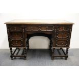 A carved leather topped oak desk, 122 x 56 x 77cm.