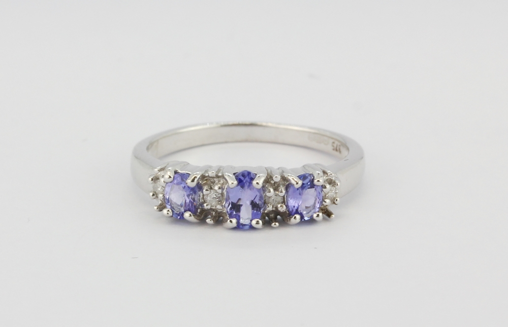 A 9ct white gold ring set with oval cut tanzanite and brilliant cut diamonds, (L).