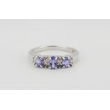 A 9ct white gold ring set with oval cut tanzanite and brilliant cut diamonds, (L).