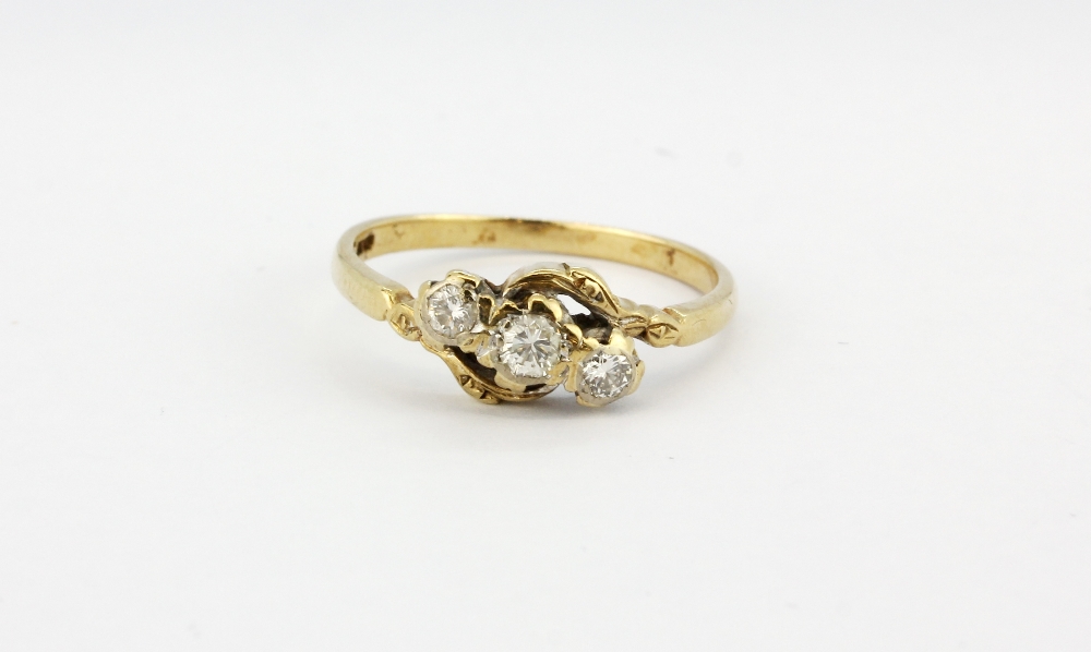 A 9ct yellow gold crossover ring set with three brilliant cut diamonds, (M).