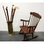 A child's rocking chair together with a hammered brass stick stand and six walking sticks.
