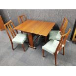 A teak veneered 1970's drop leaf dining table and four teak dining chairs.