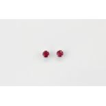 A pair of 9ct (stamped 9k) stud earrings set with round cut rubies, approx stone L. 3mm.