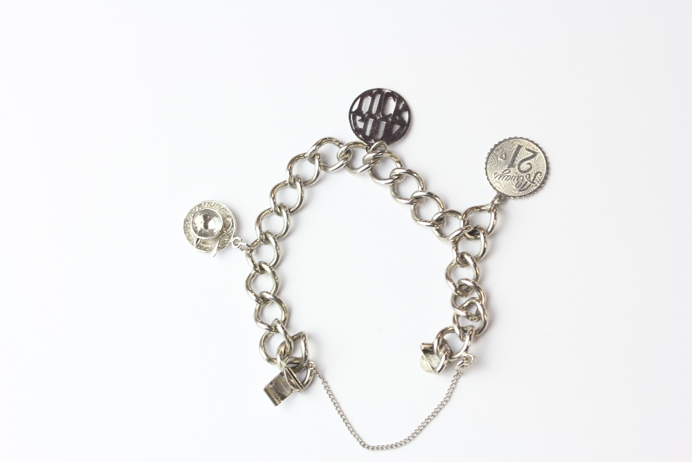 A sterling silver (approx. 25cm) flat curb bracelet with 3 assorted charms attached, a teacup and