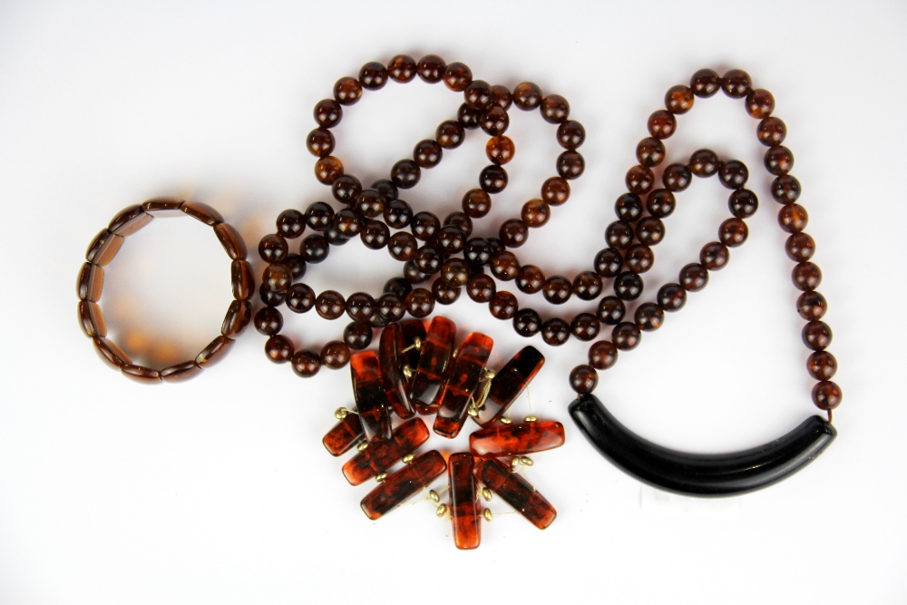 An unusual long amber bead necklace together with two amber bracelets.