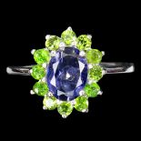 A 925 ring set with oval cut iolite surrounded by chrome diopsides, (P).