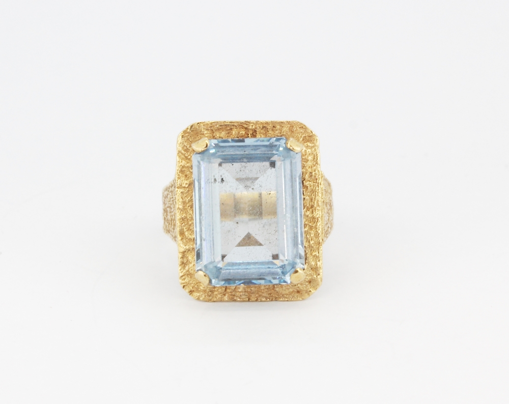 A 9ct yellow gold ring set with an emerald cut blue topaz, (O).