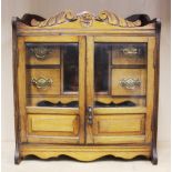 An Edwardian carved oak smokers cabinet and a collection of pipes, W. 41cm, H. 45cm, D. 20cm.