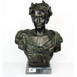 A classical bronze bust of a Roman Emperor wearing a goats head epaulette on a grey marble base,