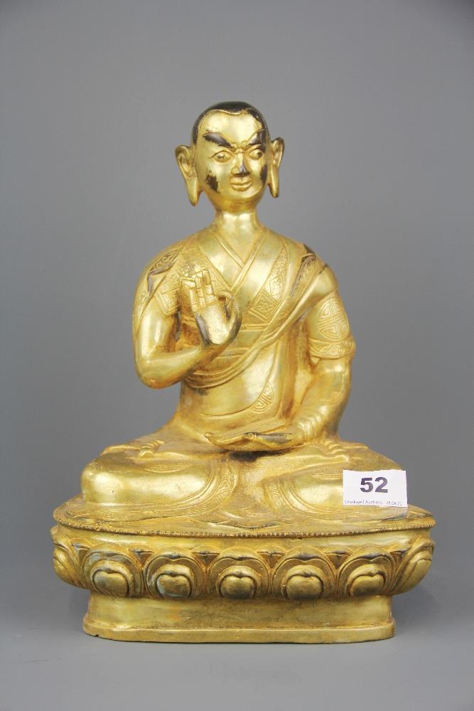 A Tibetan gilt bronze figure of a seated Buddhist deity, H. 31cm.