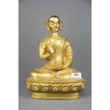 A Tibetan gilt bronze figure of a seated Buddhist deity, H. 31cm.