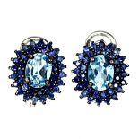 A pair of 925 silver earrings set with an oval cut blue topaz and two rows of sapphires, L. 1.7cm.