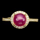 A 925 silver gilt ring set with a cabochon cut ruby and white stones, (L).