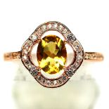 A 925 silver rose gold gilt cluster ring set with an oval cut citrine surrounded by white stones, (