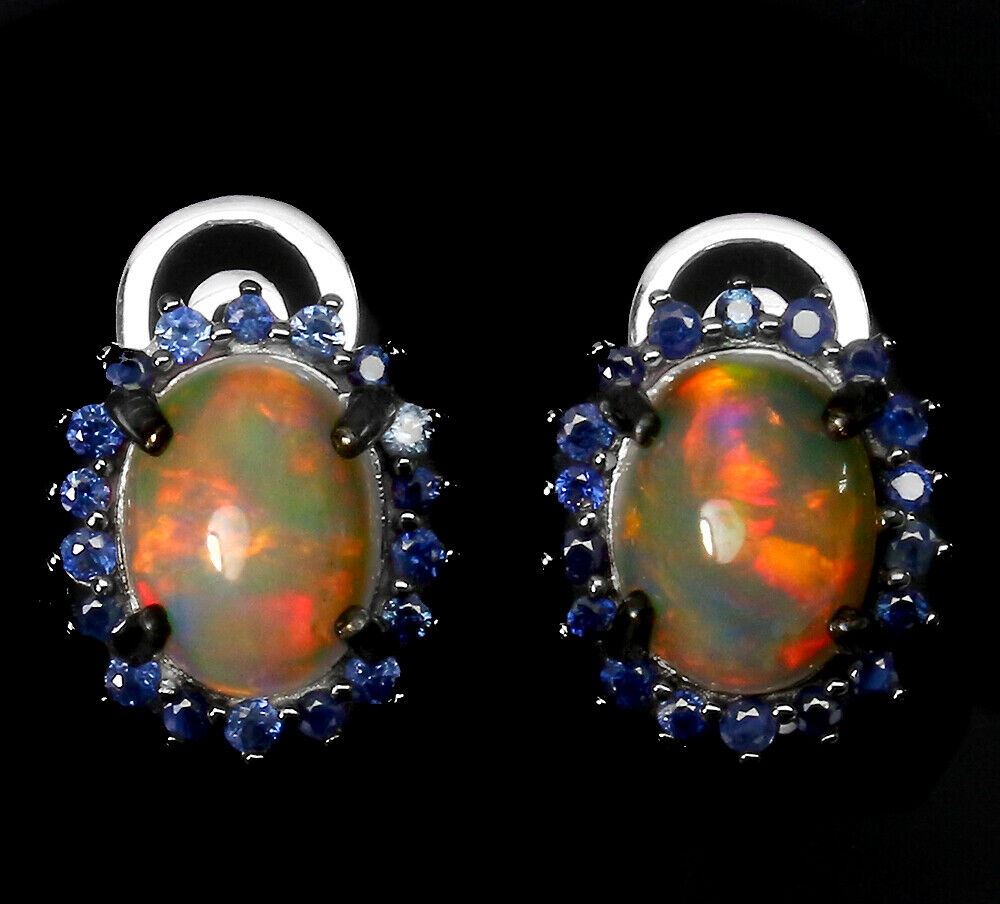 A pair of 925 silver earrings set with cabochon cut opals surrounded by sapphires, L. 1.6cm.